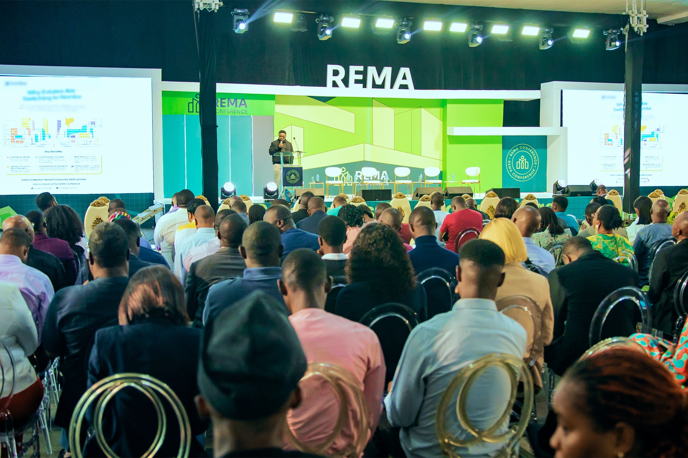 A speaker addressing a full auditorium at the REMA Conference